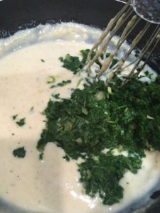 Add cooked spinach and boiled corn to the white sauce.